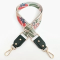 Detail of floral embroidery bag strap with green leather ends and gold metal studs - Green