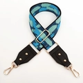 Detail of adjustable camouflage woven bag strap with black leather ends and gold rivets - Black Frame Light Blue Lens