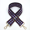 Detail eines bunten Schachbrett-Nylonschultergurts mit goldenen Metallschnallen - Navyblau und Weinrot