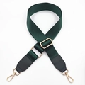 Detail of dark green nylon bag strap with gold metal buckles and black leather ends - Green