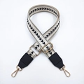 Dettaglio tracolla regolabile in nylon con motivo chevron nero e ganci dorati - Base Bianca Motivo Nero Estremità Nere