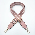 Close-up of pink nylon bag strap with white arrow pattern and golden metal hardware clips - Pink