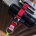 Gros plan de la sangle à bagages en nylon rouge avec boucle sur une valise - Rouge