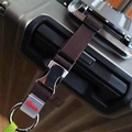 Détail d'une sangle de valise en nylon marron avec boucle en métal et anneau argenté - Café