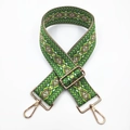 Close-up of ethnic geometric pattern strap with golden metal swivel hooks and adjuster - Green