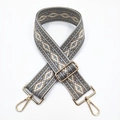 Detail view of ethnic geometric jacquard bag strap with polished gold metal hardware - Grey Khaki