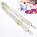 Detail view of woven adjustable bag strap in cream with golden metal swivel hooks - Gold Buckle / Off White