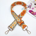 Close-up of geometric jacquard woven strap with golden metal clasps for crossbody bags - Yellow Orange Khaki