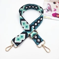 Close-up of geometric jacquard shoulder strap with golden metal lobster clasps - Blue Green Black