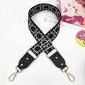 Macro detail of adjustable black ethnic wide bag strap with golden rivet and hardware - Black Network Stone