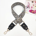 Detail view of ethnic geometric jacquard bag strap with gold metal hardware and rivets - Twist Black White Khaki