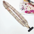 Close-up of colorful braided phone strap with gold metal carabiner and pink leather trim - Pink With Gasket