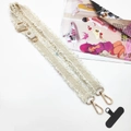 Macro shot of cream woven phone strap with gold carabiner and fringe detail - Gold Buckle / Off-White With Gasket