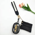 Detalle de mini bolso de cuero negro y estuche ovalado transparente en cordón a rayas - Hilo de Oro Blanco y Negro