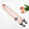 Detail of pink polyester bag strap with white stripes and black plastic swivel hooks - Light Pink + Black Buckle