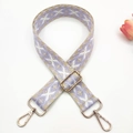 Close-up of ethnic geometric jacquard wide bag strap with gold metal lobster clasps - Beige Base Purple