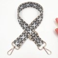Close-up of geometric ethnic embroidery on thick woven bag strap with gold metal buckles - Beige with Grey