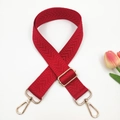 Detail of red herringbone bag strap with golden lobster clasps and metal buckle - Red