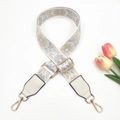 Close-up of ethnic style woven handbag strap with cream leather and gold metal clips - Gold Buckle / Grey/Beige on White