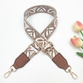 Detail of bohemian geometric floral woven strap with gold metal hooks and brown leather ends - Beige Background Red Bean Paste Brown with Brown