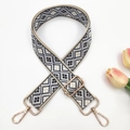 Close-up of ethnic geometric weave bag strap with golden metal lobster clasps - Gold Buckle / Beige Navy Blue