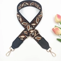 Close-up of ethnic jacquard guitar style bag strap with leaf pattern and gold hooks - Black Coffee