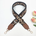 Detail of ethnic style woven bag strap with geometric patterns and golden metal clasps - Black Base Brown + Brown