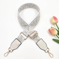 Detail of adjustable woven wide shoulder strap with gray leaf jacquard and gold metal hooks - White Background Gray