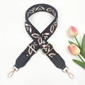 Close-up of ethnic geometric woven bag strap with golden metal lobster clasps - Coffee on Black