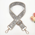 Close-up of adjustable geometric weave handbag strap with gold-tone hardware and tulip - Beige with Grey