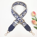 Detail of wide embroidered bag strap with blue leaf pattern and gold metal buckles - Blue on Beige