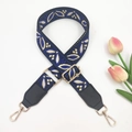 Detail of adjustable woven wide strap with leaf pattern and gold metal hooks - Black Base Blue + Black