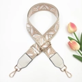Close-up of adjustable embroidery bag strap with floral patterns and golden metal buckles - Flesh Pink on Beige