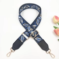 Detail of blue vintage floral embroidery bag strap with gold hooks on white background - Lake Blue on Black