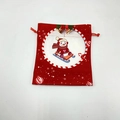 Close-up of a red Christmas drawstring gift bag featuring a cute snowman design and gold bell - Red Sleigh Snowman