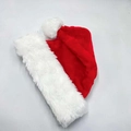 Detailansicht des weißen Plüschbesatzes und roten Samtstoffs auf einer Weihnachtsmütze - Rot