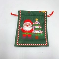 Close-up of green Christmas drawstring gift bag with Santa Claus and tree illustration - Green Christmas Tree Gnome