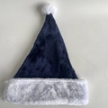 Dettaglio del cappello di Natale blu scuro con bordo in ecopelliccia bianca e pompon - Blu navy