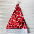 Detailed view of red glossy Christmas hat featuring white heart and bow patterns and fur trim - Red (Heart)