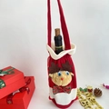 Detail of red wine bottle cover with 3D plush reindeer and festive checkered bow - Red