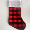 Klassieke rood-zwarte geruite kerstsok met een witte rand van imitatiebont op een witte achtergrond - Rood en zwart geruit