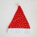 Detail of red plush Christmas hat featuring silver snowflake prints and a white pompom - Red Moon Style