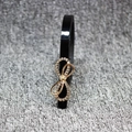Slim black patent leather waist belt for women with a gold rhinestone bow buckle - Black