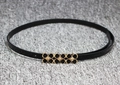 Detail eines schmalen schwarzen Lackledergürtels mit dreifacher Goldblumenschnalle - Schwarz