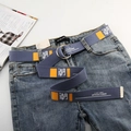 Detail eines blauen Stoffgürtels mit orangefarbenem Aufdruck und Doppel-D-Ringschnalle - Blau Denim