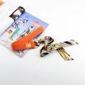 Détail de la ceinture en toile orange avec écusson marguerite et foulard en soie imprimé - Style Marguerite Décoré d'une Écharpe en Satin / Orange