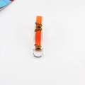 Detail view of the cream canvas belt featuring orange stripes and butterfly print with D-ring - Orange with Apricot Edge