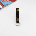 Close-up of canvas belt strap with yellow butterfly embroidery and silver D-ring buckle - Black with White Edge