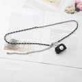 Detalle de cinturón de cadena plateada con cuero negro y mini bolso con perla - Cadena Tejida de Cuero (Bolso con Botón de Perla)