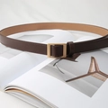 Detailed view of dark brown belt with matte gold buckle on a minimalist magazine - Pearl Gold Buckle (Coffee)